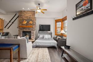 a living room with a bed and a fireplace at Shared Hot Tub,1 Car Garage, Dining & Grocery, Walk to Shops, On Bus Route in Steamboat Springs