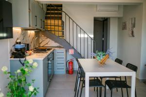 a kitchen with a staircase and a table and chairs at Oktolia suites in Alexandroupoli
