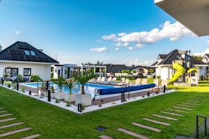 a backyard with a pool and a slide at Family Resort Ustka - Domki dwupoziomowe z basenem , sauna , balia in Ustka