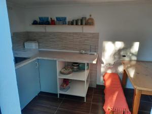 a small kitchen with a counter and a table at Vikendica Breza 2 in Zaovine +4 photos