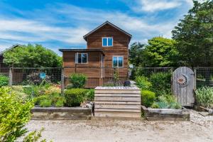 a small wooden house in a garden at Coastal Cove Cottage in Ocean Bay Park