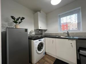 a kitchen with a refrigerator and a washing machine at Kilnview Guesthouse-Hanley & Staffordshire University in Stoke on Trent
