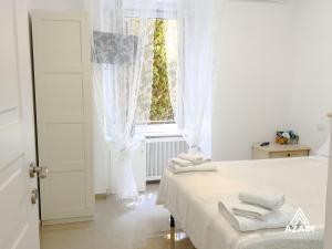 a white bedroom with a bed and a window at Azadi B&B Flaminio in Rome
