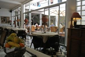 a restaurant with tables and chairs and people sitting at tables at Hôtel La Résidence in Saint-Louis