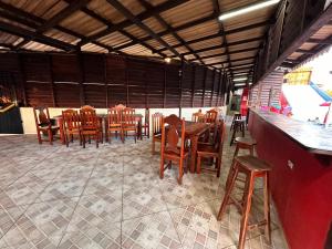 a restaurant with wooden tables and chairs and a bar at Hotel La Villa Morena in Oiapoque