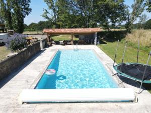 a swimming pool with a gazebo in a backyard at Au Petit Galop in Nassiet