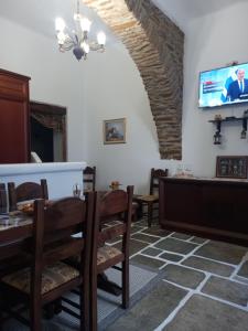 a dining room with a table and chairs and a tv at Το Πέτρινο in Kithnos