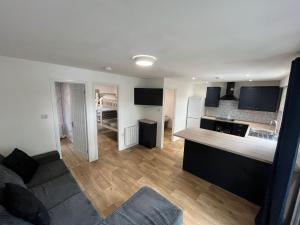 a kitchen and a living room with a couch and a kitchen and a kitchen at Eryri Lodge in Caeathro