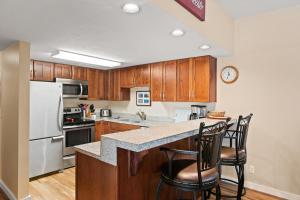 una cucina con mobili in legno e un frigorifero bianco di Pools and Hot Tubs, Free Bus & Private Shuttle, Ground Floor a Steamboat Springs