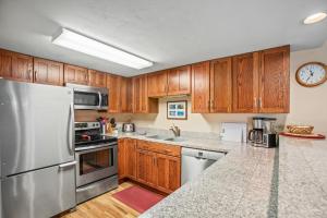 una cucina con armadietti in legno ed elettrodomestici in acciaio inossidabile di Pools and Hot Tubs, Free Bus & Private Shuttle, Ground Floor a Steamboat Springs