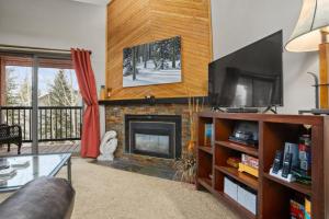 Una sala de estar con chimenea y televisión. en 3 Hot Tubs, Private Shuttle in Winter, Gas Fireplace, Free Bus, en Steamboat Springs