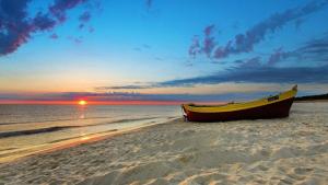 a boat sitting on the beach at sunset at La Marina Bay in Vieste