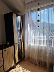 a room with a large window with white curtains at Apartament w Centrum in Międzybrodzie Bialskie