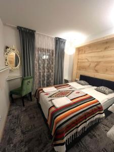 a bedroom with a bed and a green chair at Chałpa z bali in Zakopane