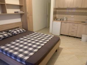 a bedroom with a checkered bed in a kitchen at Apartments Nurkovic in Dobra Voda