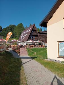 a building with a restaurant with tables and umbrellas at Donovaly apartmán 33 in Donovaly