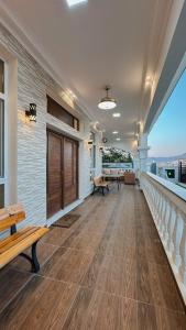a large room with wooden floors and a balcony with benches at سمارت شاليه: Smart Chalet in Salalah