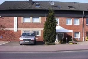 a car parked in front of a brick building at Donatus Hotel in Brauweiler