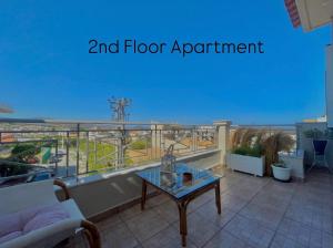 a balcony with a glass table and floor apartment at Aggelou Apartments-10 mins from Athens airport in Spata
