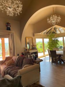 a living room with a couch and a table at Villa vue panoramique, 6 chambres, piscine chauffée in Espalion