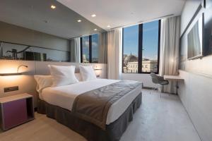 a bedroom with a large bed and a large window at Negresco Princess 4* Sup in Barcelona