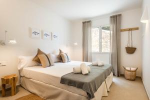 a bedroom with a large white bed with a window at Villa Atalis in Son Bou +34 photos