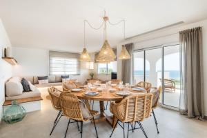 a dining room and living room with a table and chairs at Villa Atalis in Son Bou