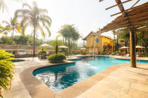 a swimming pool with blue water in a resort at FLAT 3-107 - Iha Flat Hotel - Pereque - Ilhabela in Ilhabela