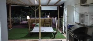 um alpendre com um relvado verde e um grelhador em Patoulocation em La Trinité