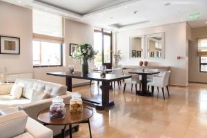 a living room with tables and chairs and a couch at Ayia Marina Suites in Ouranoupoli