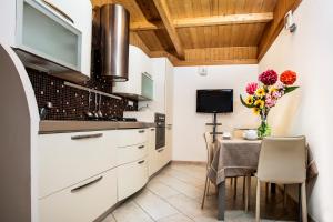 una cocina con armarios blancos y una mesa con flores en Green Paradise Resort en Otranto