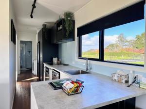 a kitchen with a counter and a large window at Peachy On Pembroke stunning mountains views with 9 hole Mini Putt in Stratford
