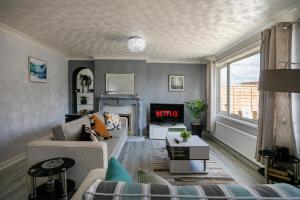 a living room with a couch and a fireplace at Wickersley House, Rotherham for contractors & Families, free parkin, wifi etc in Wickersley