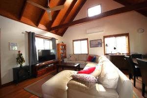 un salon avec un canapé blanc et une télévision dans l'établissement Kookaburra Cottage 71 Straight St HH, à Hat Head