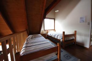 deux lits jumeaux dans une chambre aux murs en bois dans l'établissement Kookaburra Cottage 71 Straight St HH, à Hat Head