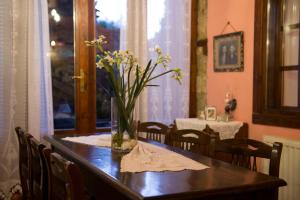 a dining room table with a vase of flowers on it at Varosi Guesthouse in Edessa