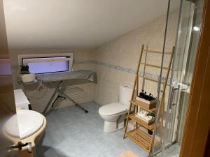a bathroom with a toilet and a glass shower at DUPLEX LUMINOSO Y TRANQUILo in El Pont de Vilumara +27 photos