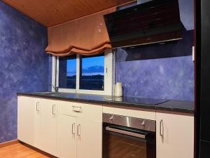 a kitchen with white cabinets and a window at DUPLEX LUMINOSO Y TRANQUILo in El Pont de Vilumara