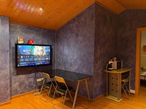 a room with a table and a tv on a wall at DUPLEX LUMINOSO Y TRANQUILo in El Pont de Vilumara