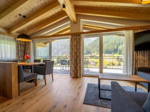 ein Wohnzimmer mit Tisch und großem Fenster in der Unterkunft Chalet Pettneu am Arlberg - Top 4 in Pettneu am Arlberg