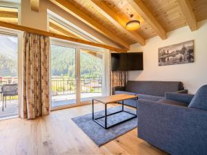 ein Wohnzimmer mit einer Couch und einem Tisch in der Unterkunft Chalet Pettneu am Arlberg - Top 4 in Pettneu am Arlberg