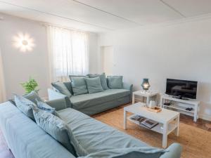 a living room with a blue couch and a tv at La Maison sur la Colline in Laprade