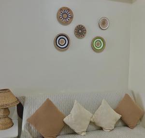 a wall with plates on a wall with a couch at Lake View Wind SMDC Tagaytay in Tagaytay