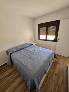 a bedroom with a bed with a blue comforter and a window at Ático Alameda in Santa Cruz de la Palma +11 photos