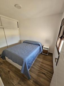 a bedroom with a bed with a blue blanket on it at Ático Alameda in Santa Cruz de la Palma