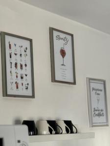 three pictures on a wall above a shelf with glasses at Rose in Bellême +20 photos