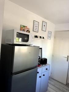 a kitchen with a microwave on top of a refrigerator at Rose in Bellême