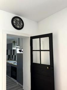 a clock on a wall above a door in a kitchen at Rose in Bellême