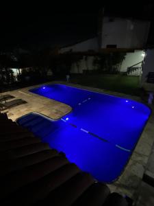 Ein blauer Swimmingpool bei Nacht mit blauer Beleuchtung in der Unterkunft Pousada Vila Italia - Porto da Dunas in Aquiraz + 49 Fotos
