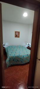 ein Schlafzimmer mit einem Bett mit einer blauen Bettdecke in der Unterkunft Departamento Centrico Cordoba in Cordoba